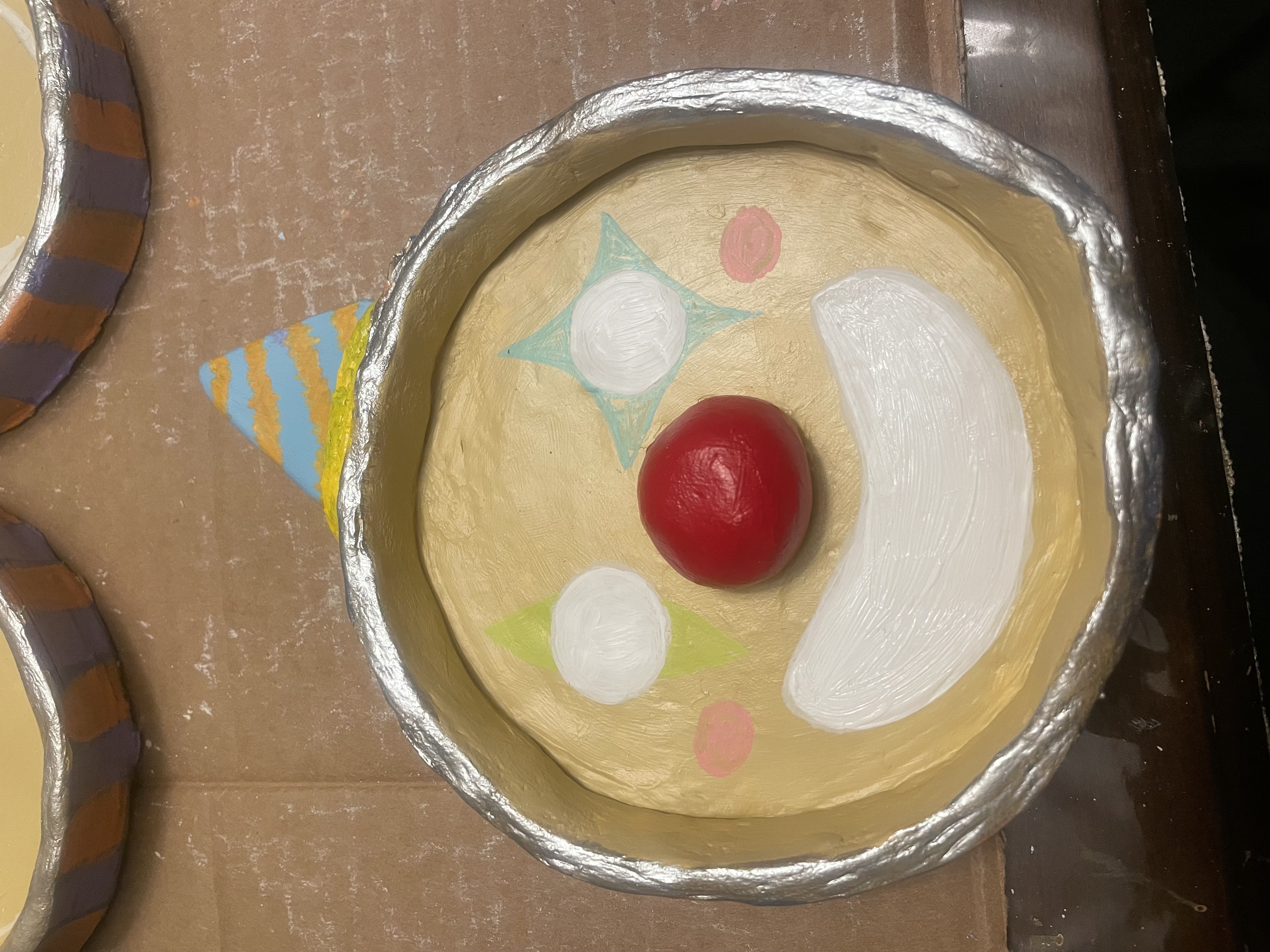 Sinthia adding detail to a clown clay dish by Choonie